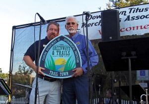 Mr. Parks Edie Small, Assistant Director of Central Operations with the Florida Department of Environmental Protection, Division of Recreation and Parks (left) and Walt Johnson, Mayor of the City of Titusville celebrate Titusville being named a "Trail Town"