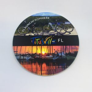 Launch From Here coaster featuring bikes and a sunset at the marina