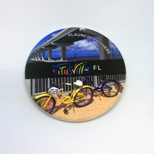 Launch From Here coaster featuring bikes in front of the A. Max Brewer Bridge